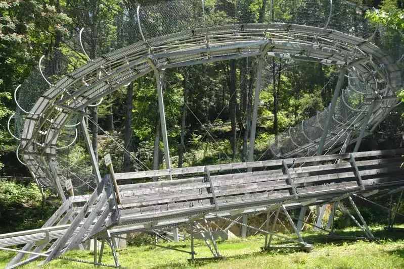 The curving track of a mountain coaster winds down the mountain.