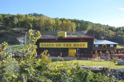 The exterior of the Goats on the Roof building with the mountain coaster in the background.