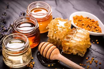 pots of honey, honey comb, and bee pollen