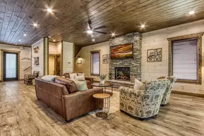 couches, chairs, and stone fireplace in rocky top plunge cabin in pigeon forge